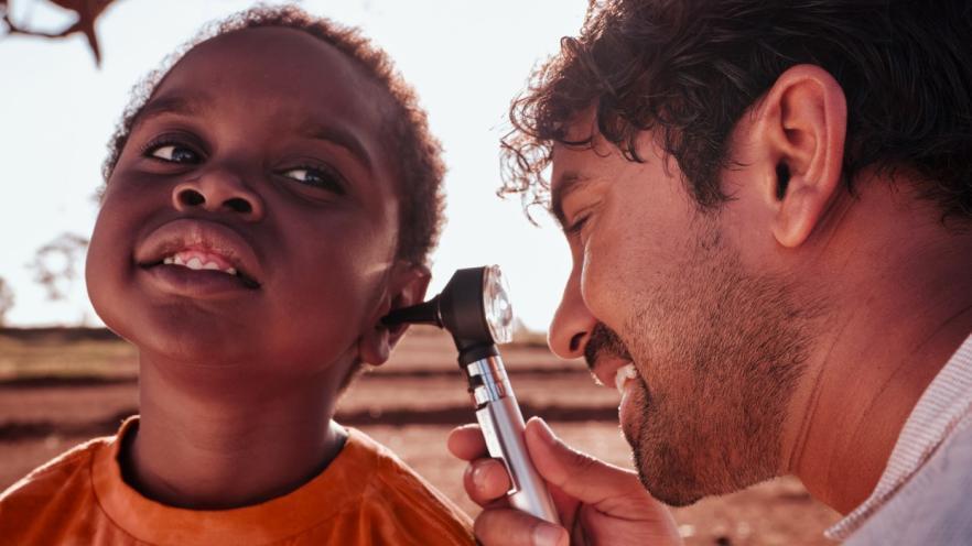 Doctor examining the ear of a young child